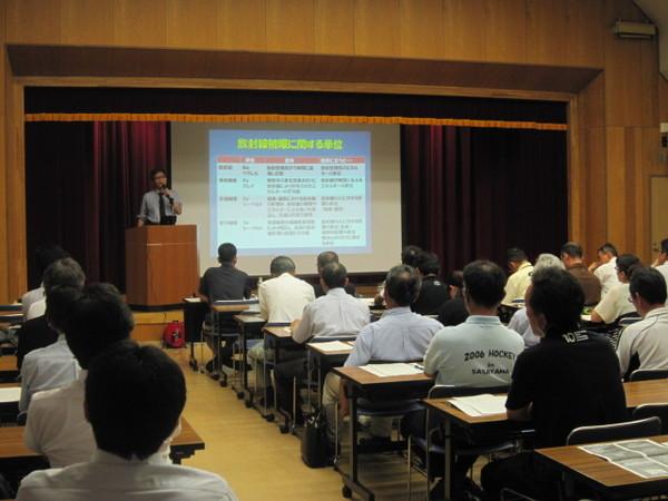 着席し、プロジェクトスクリーンをみている防災研修参加者の写真